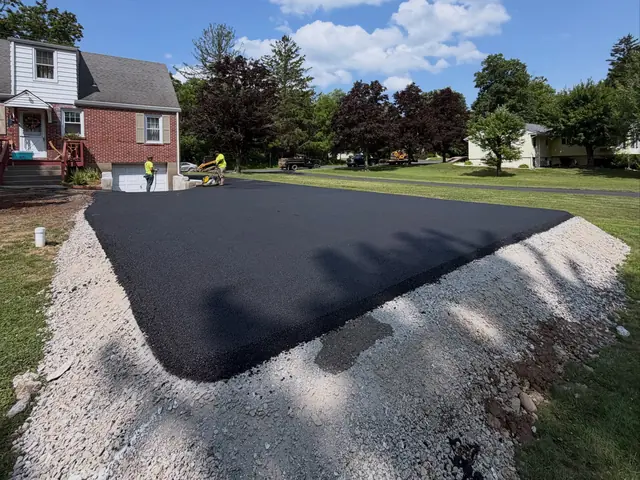 New asphalt driveway apron edged with crushed stone before topsoil and seeding