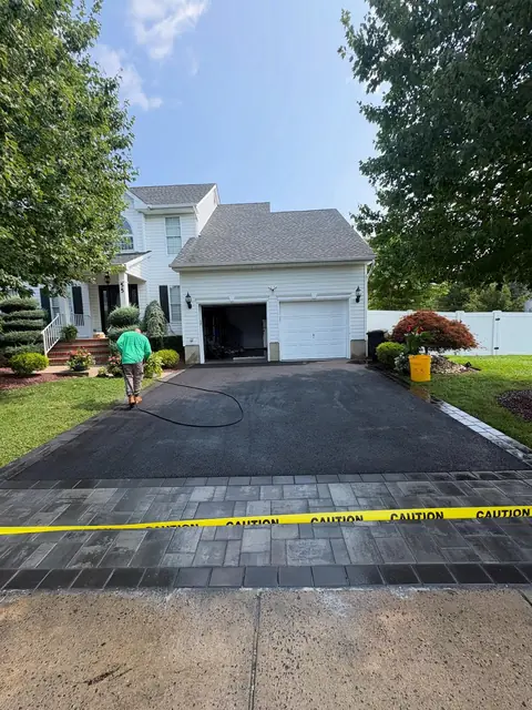 New asphalt driveway finished with a paver apron at the sidewalk