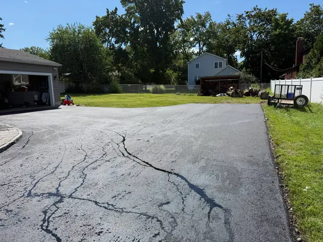 Asphalt driveway with filled cracks before resurfacing
