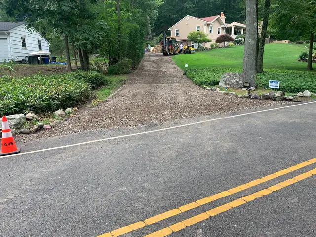 Driveway sub-base graded and pitched toward the road before asphalt