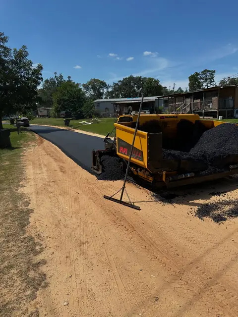 Asphalt paver starting work on a prepared gravel driveway base