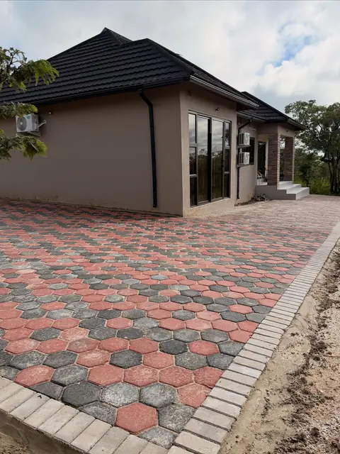Red and gray hexagon paver patio with a contrasting soldier-course border