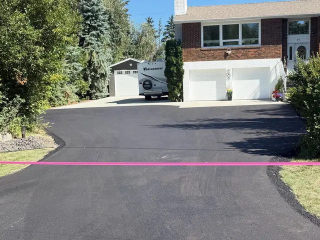 Replaced asphalt driveway in front of a two-car garage