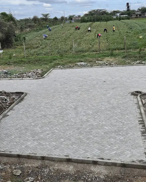 Wide light gray paver parking court with defined borders